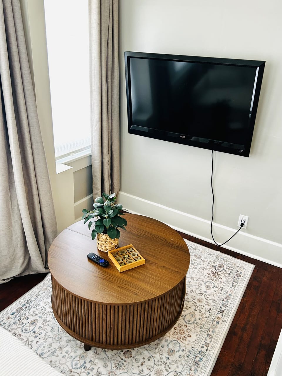 Bright, cozy lounge area with wall-mounted TV and stylish wood coffee table
