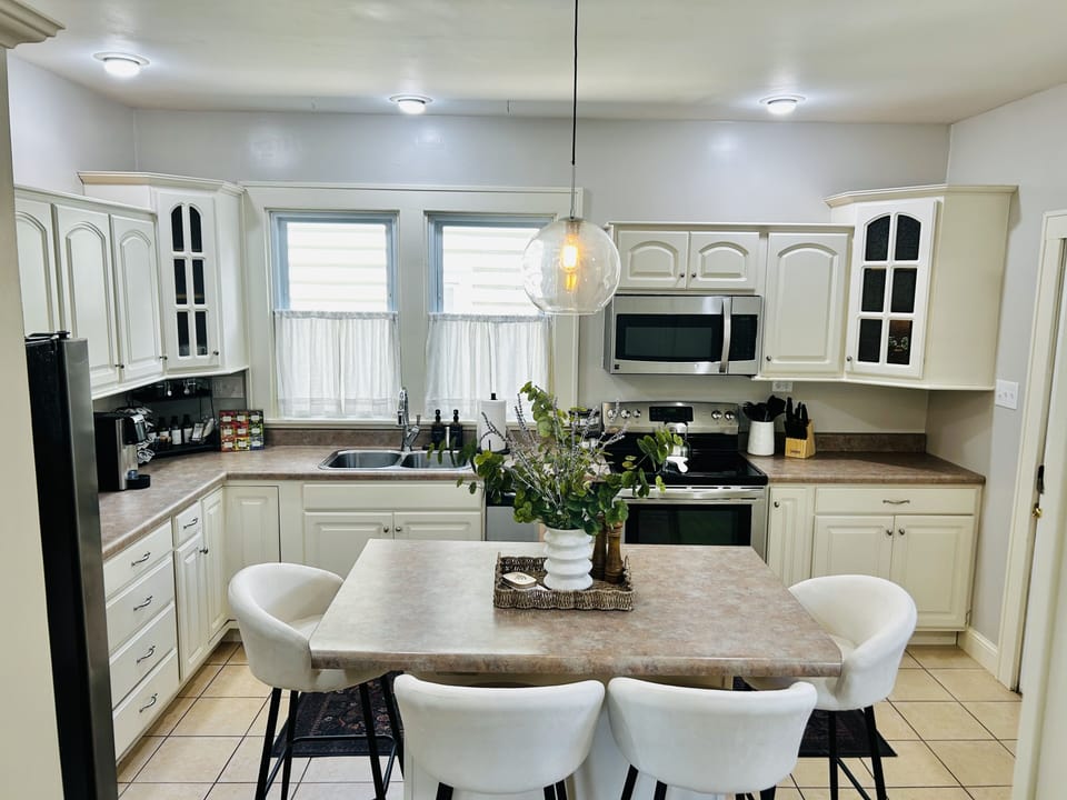 Bright modern kitchen with island seating and stainless steel appliances