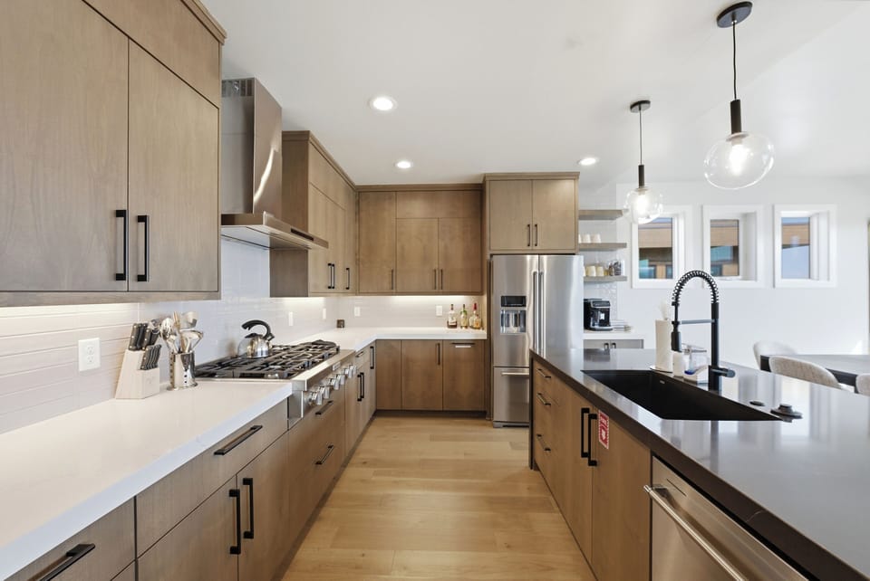 Cook with ease in the modern kitchen, featuring premium appliances, a spacious island, and seating for three.