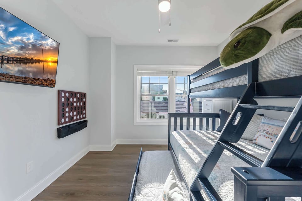 A cozy bunk room perfect for kids, complete with a TV and trundle bed.