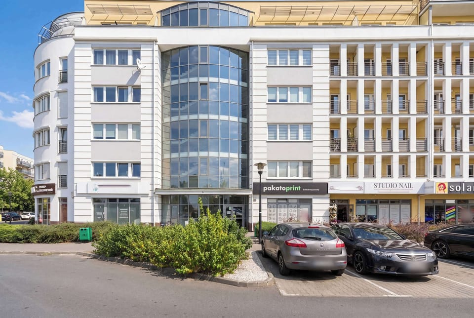 A modern multi-story building with elegant architecture, large windows, and a spacious entrance area.
