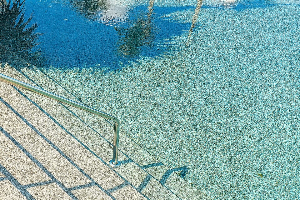 Dip your toes into sparkling water under dappled palm shadows.