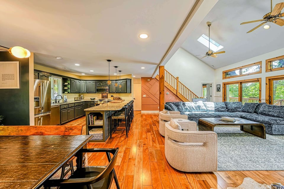 Open Layout - The kitchen and island flow into the living area under a vaulted, skylit ceiling.