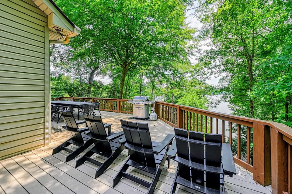 Deck Living - Adirondack loungers up front with a dining table and grill just beyond, wrapped in treetop privacy.