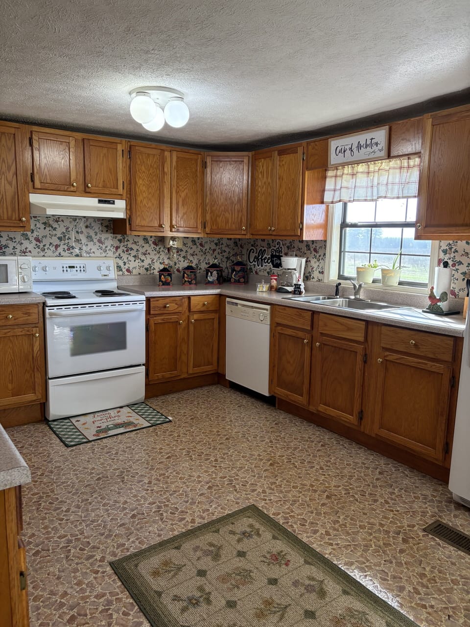 Sunny country kitchen with oak cabinets, coffee bar, and full-size appliances.