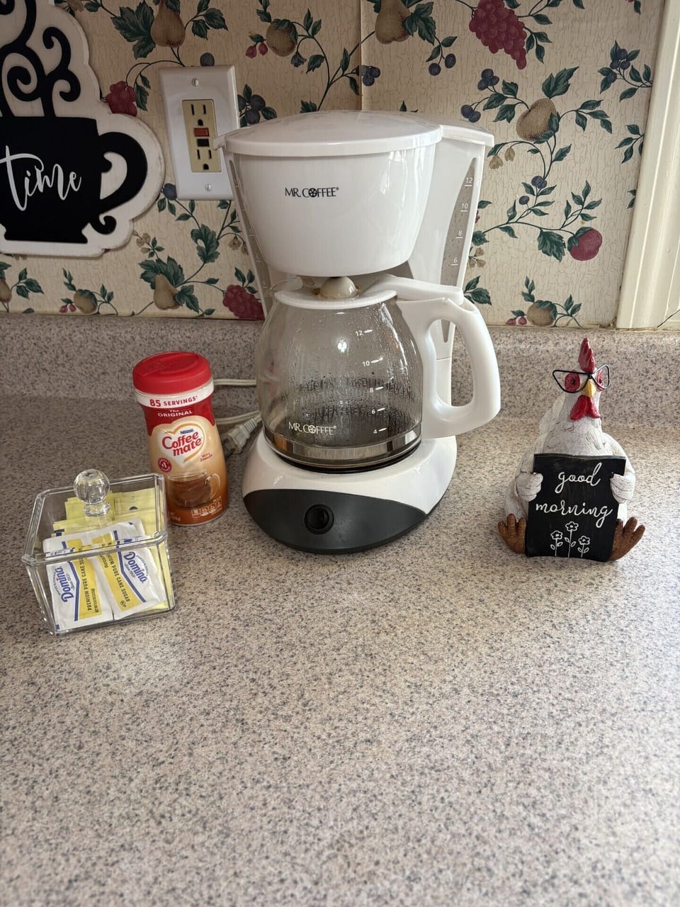 Morning-ready coffee station with drip maker, creamer & sweeteners.