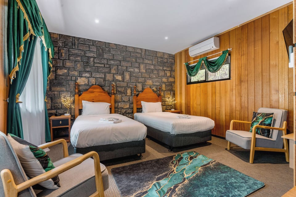 Cozy twin room with stone accents, seating area, and stylish decor
