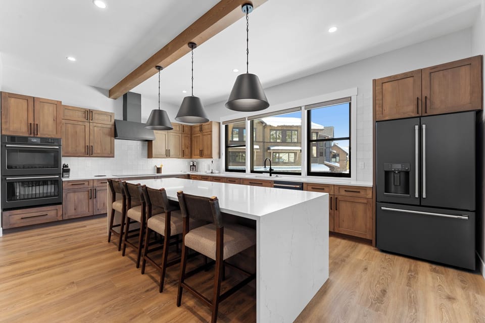 Full-sized kitchen with double ovens, induction cooktop, and seating for 4.