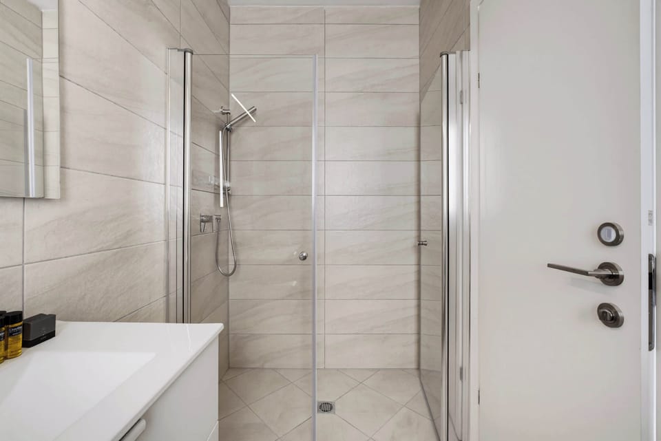 Sleek glass enclosures and premium fixtures highlight the contemporary design of this immaculate, walk-in shower area.