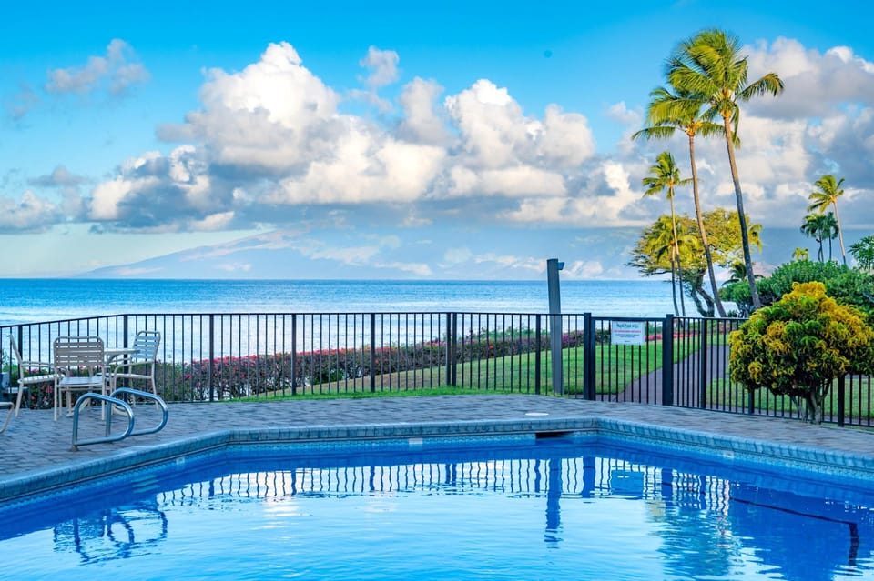 Soak in panoramic ocean views from the pool deck at Napili Point, where swaying palms and calm waters create a peaceful, picture-perfect escape.