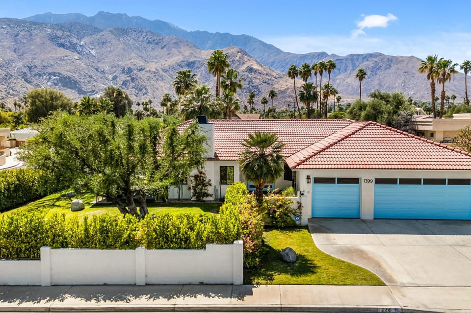 Front exterior with mountain backdrop and private driveway