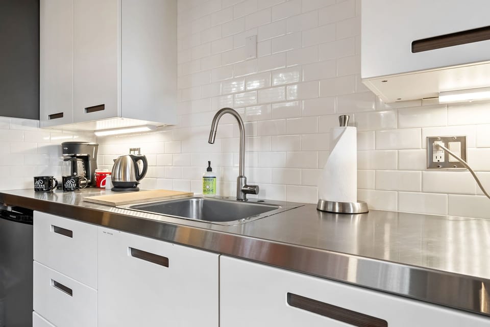 Your modern kitchen awaits with sleek stainless steel counters, subway tile backsplash, and all the essentials for preparing meals during your stay.