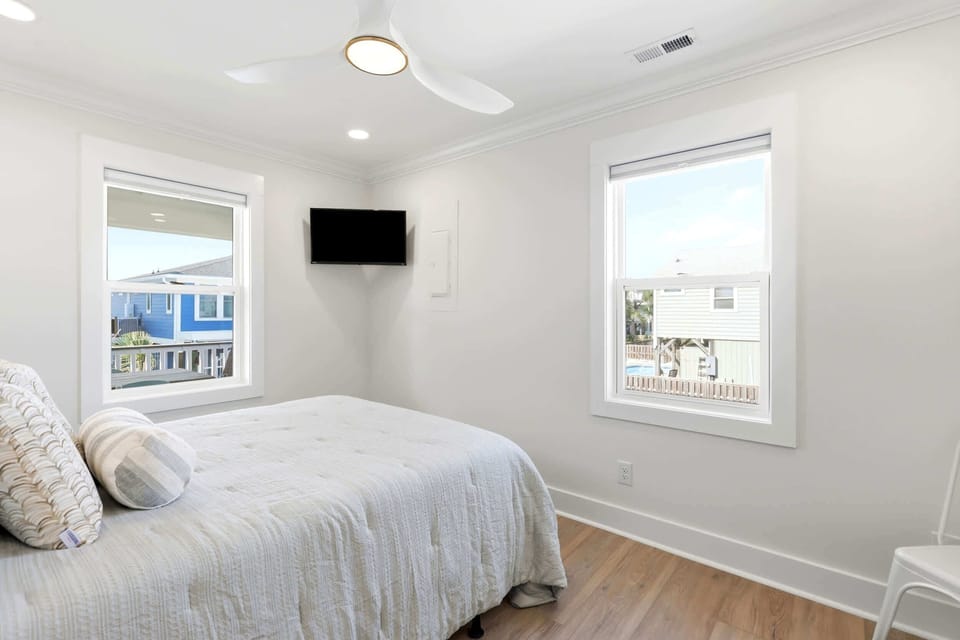 Spacious bedroom with a smart TV, offering a cozy and comfortable space to relax and enjoy a quiet night in after the beach.