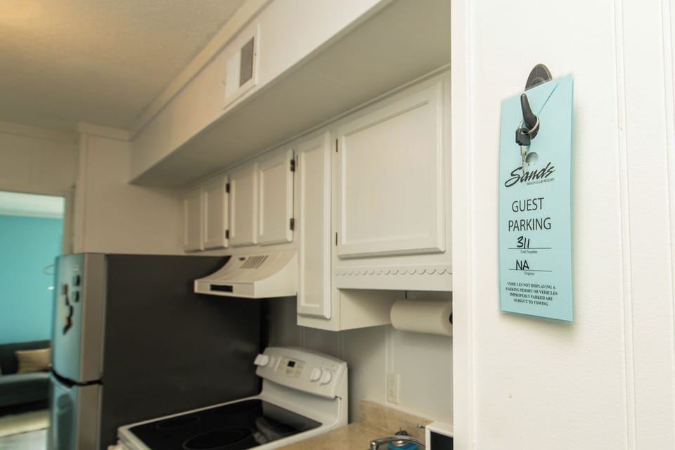 Bright white kitchen with full stove and convenient guest parking access
