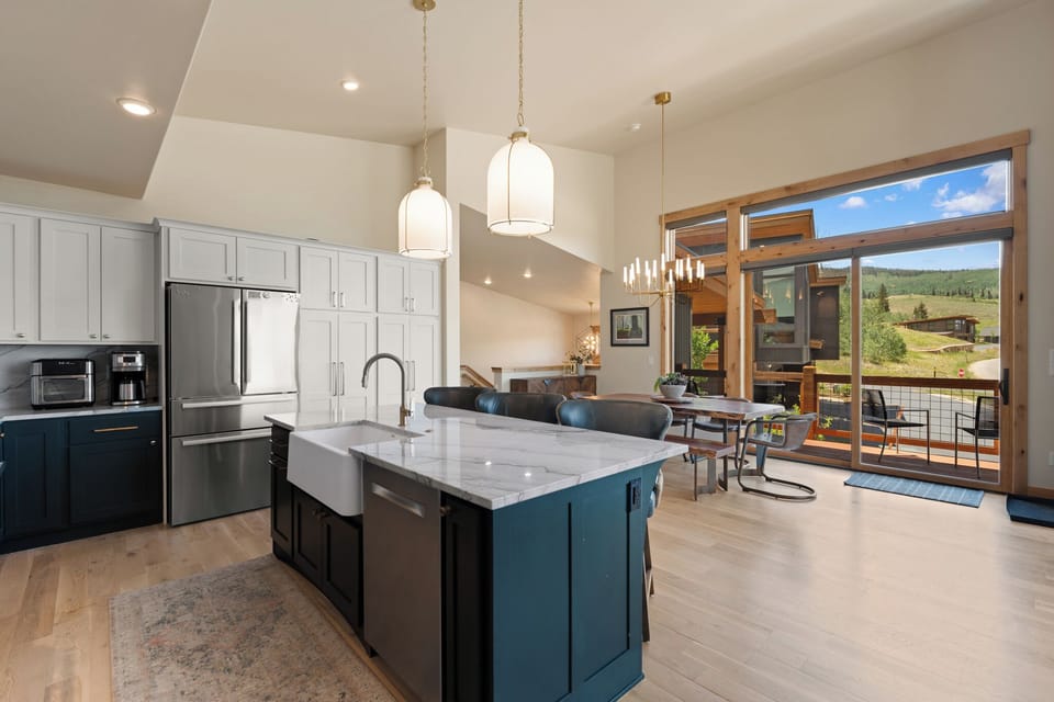 Sunlight streams through expansive windows, illuminating your beautifully appointed chef's kitchen and inviting dining space, where mountain vistas frame every meal you'll enjoy.