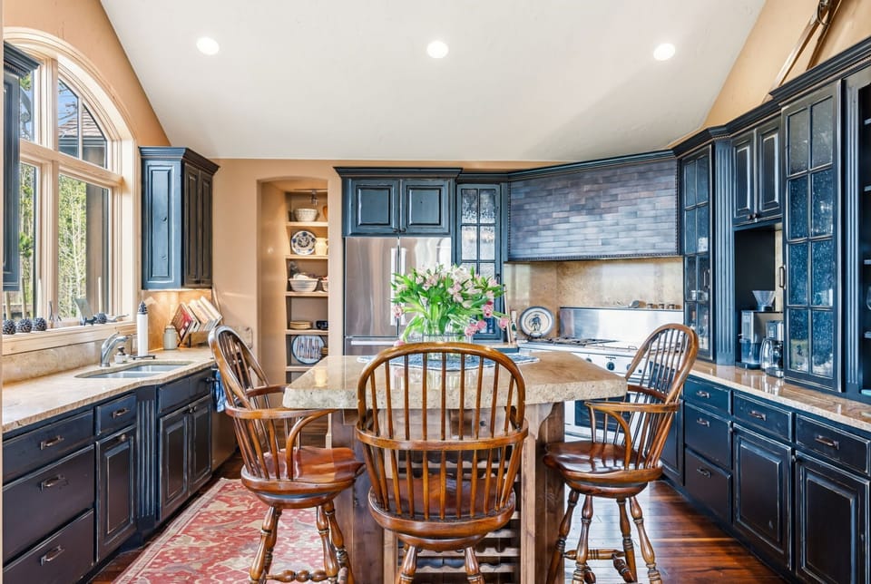 A fully equipped kitchen with rich cabinetry, granite counters, and a cozy breakfast nook — everything your group needs to cook, dine, and linger over morning coffee.