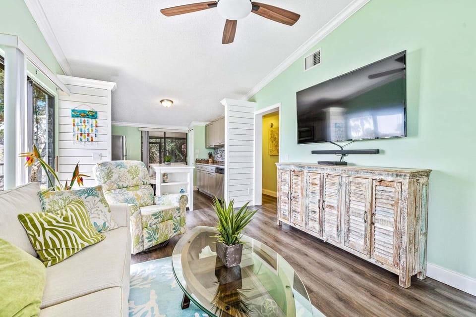 Kick back and relax in the bright, coastal-inspired living room featuring comfortable seating, a large Smart TV, and an open layout that's perfect for unwinding after a day at the beach.