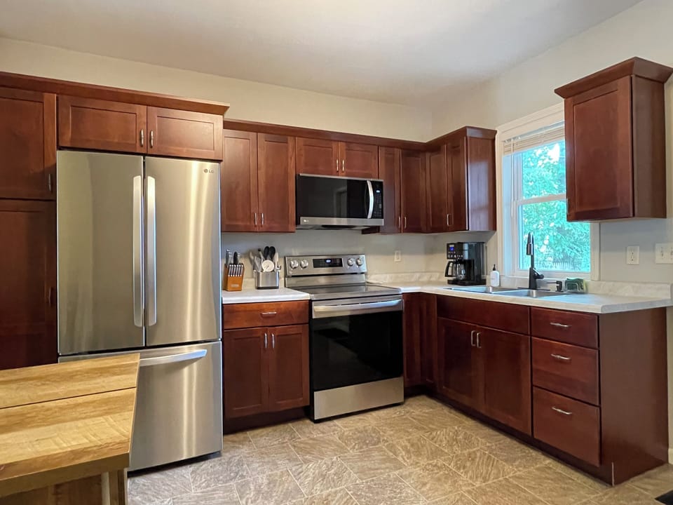 Downstairs cabinets are filled with kitchen supplies including mixing bowls, baking sheets, measuring cups, cutting boards, and food storage containers