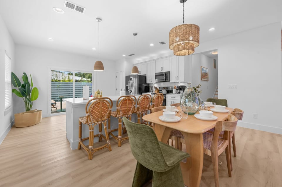 Bright open kitchen and dining space with island seating and patio access