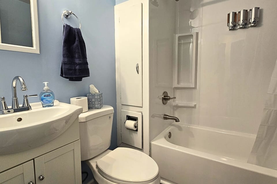Sparkling bath with tub/shower, storage, and refillable toiletries.