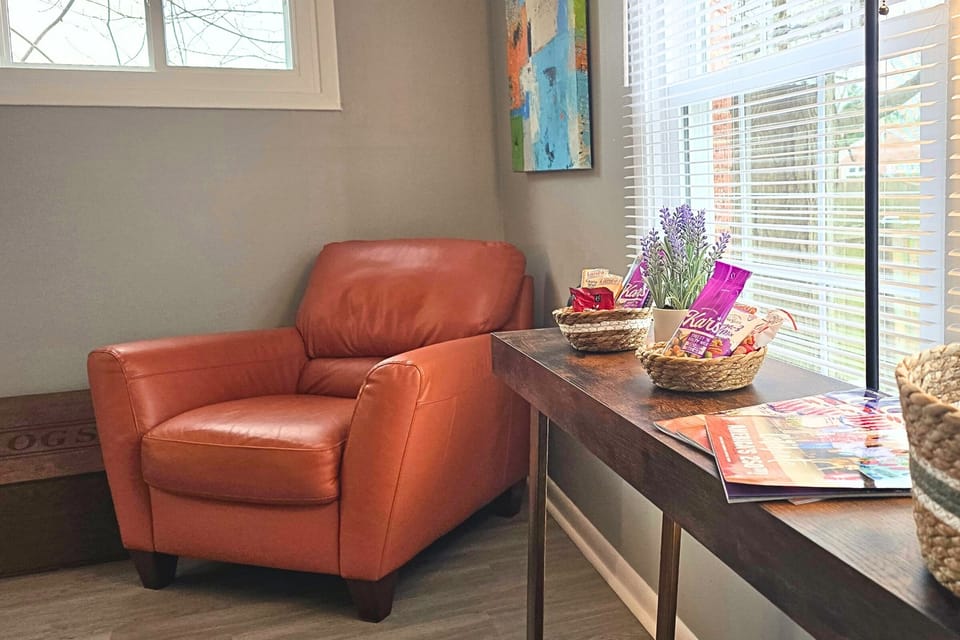 Sunny reading nook with leather chair and welcome snack baskets