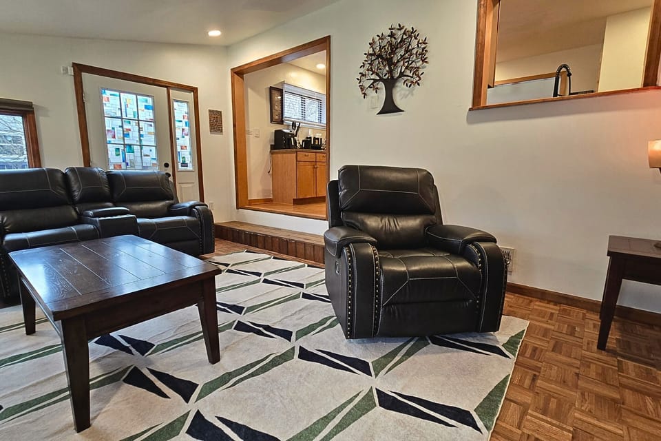 Cozy living room with leather recliners & pass-through kitchen