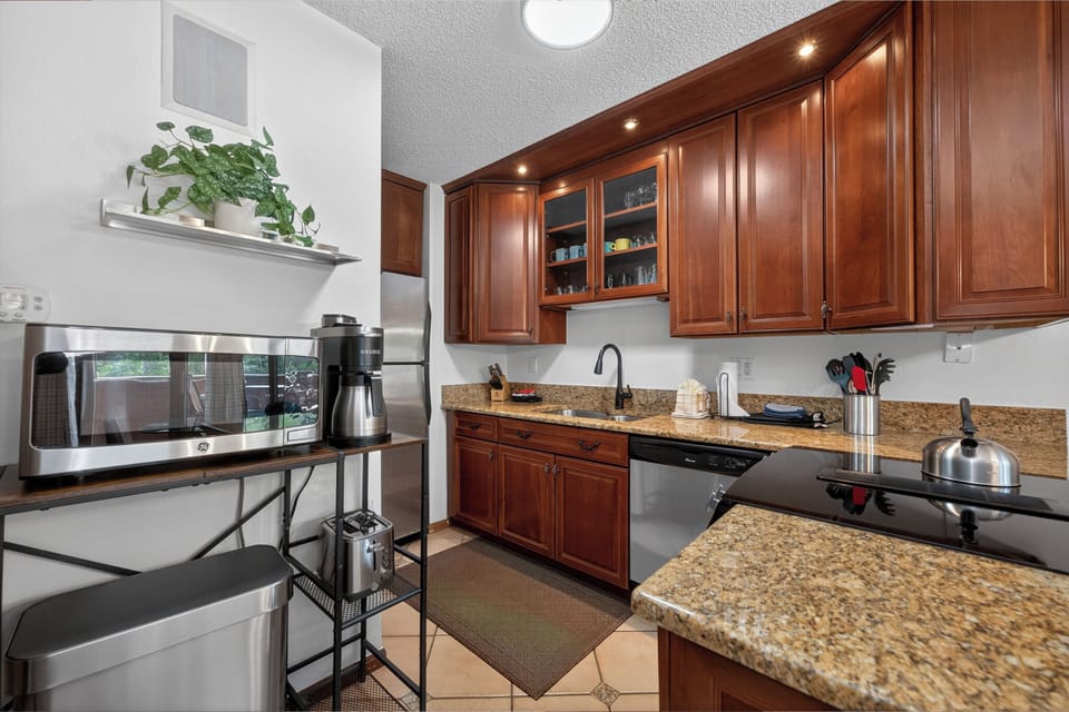 Your fully-equipped kitchen features rich wood cabinetry, granite countertops, and modern stainless appliances—perfect for preparing meals during your stay.
