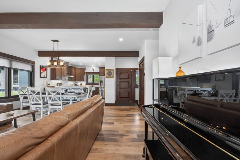 Relax in this open-concept living space where rustic beams meet modern comfort. Gather around the dining table, unwind on plush seating, and enjoy mountain views streaming through expansive windows.