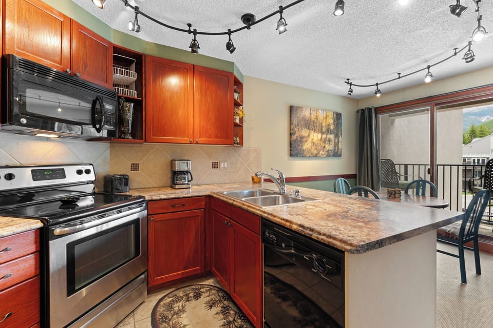 Step into your fully equipped kitchen with granite counters, stainless appliances, and bright track lighting. Cook meals together, share stories at the breakfast bar, and enjoy mountain views from your private balcony.