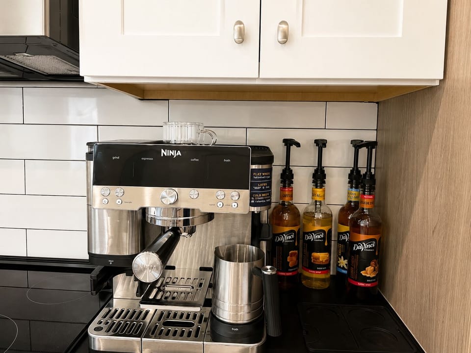 Stylish coffee bar with espresso maker, frother, and flavored syrups