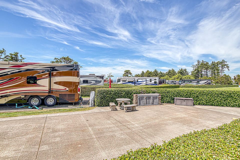 The property features a private paved patio area with outdoor seating and manicured hedges, offering a peaceful outdoor space for relaxation.