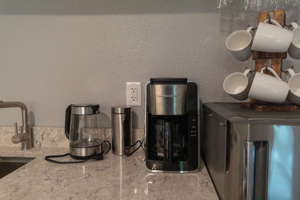 Dedicated coffee station with a drip maker, electric kettle, and mugs!