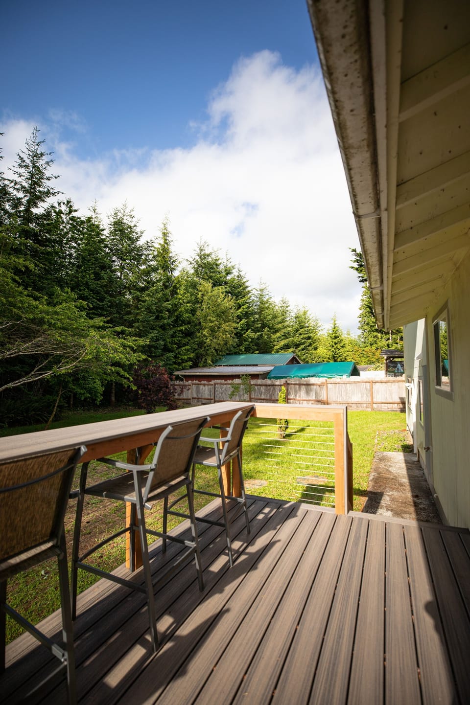 Expansive back deck with custom bar seating overlooking the private yard.