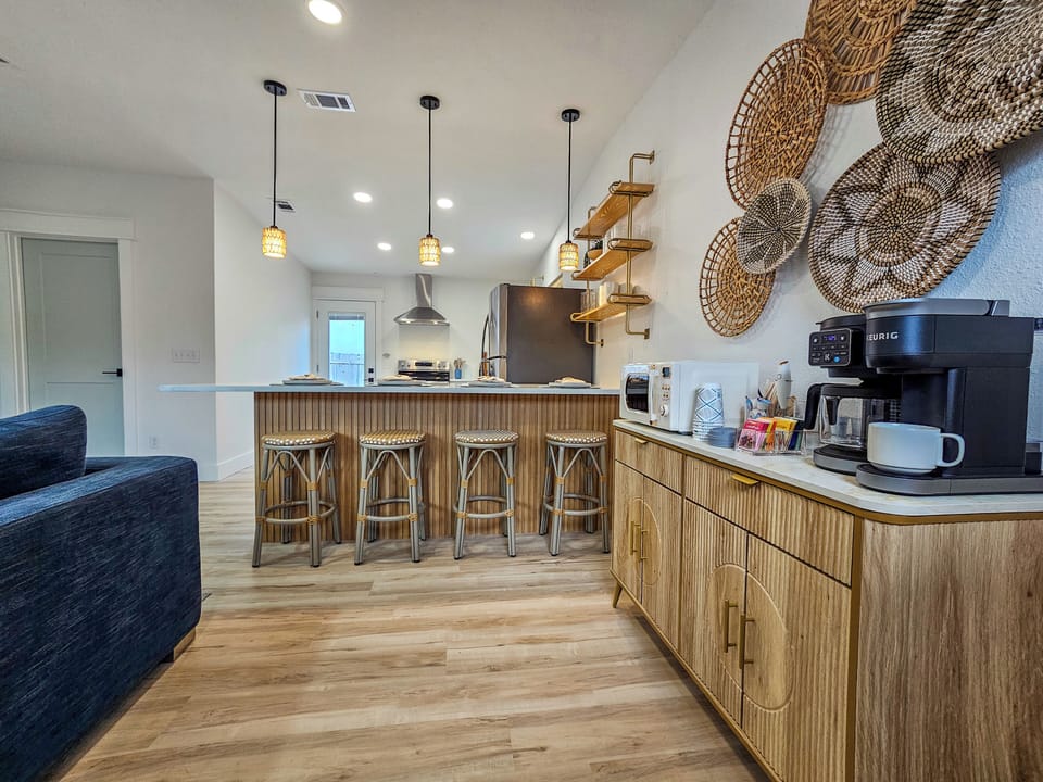 Modern coastal kitchen with island seating and coffee bar.