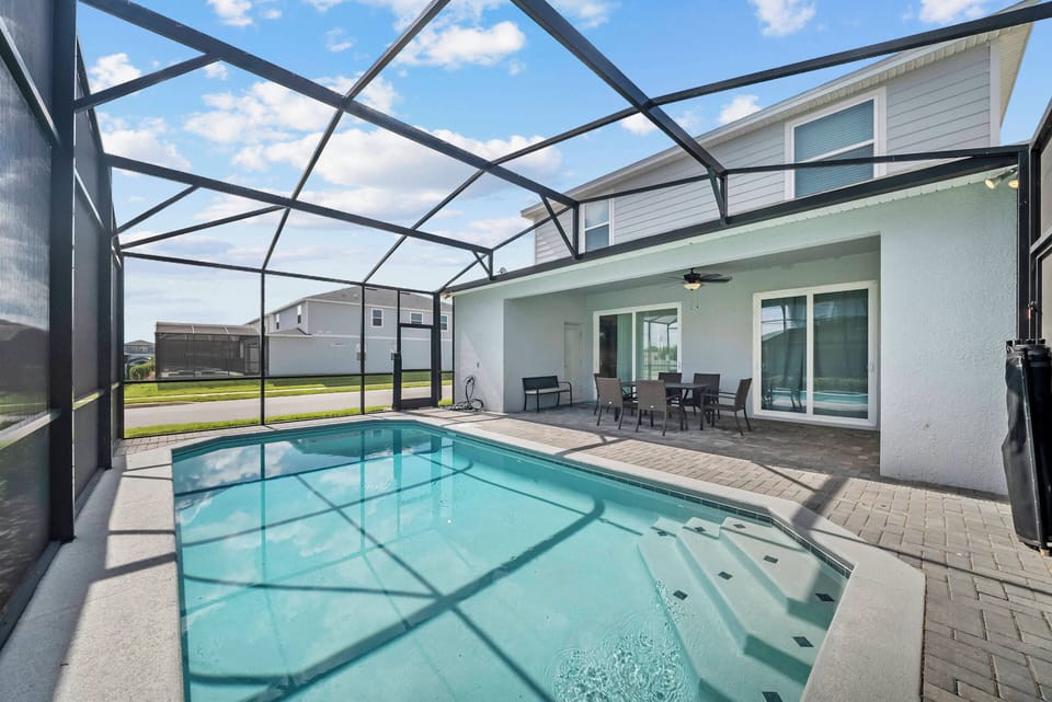 Step outside to your private pool area, framed by a sleek screen enclosure that allows for ample sunlight. The modern seating invites you to relax and enjoy the tranquil view, making it the ideal spot for leisurely afternoons.