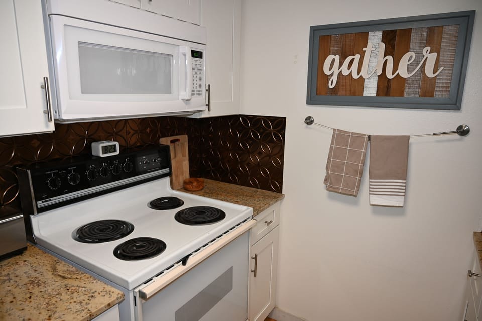 Cozy kitchen with full stove, microwave, and inviting modern touches