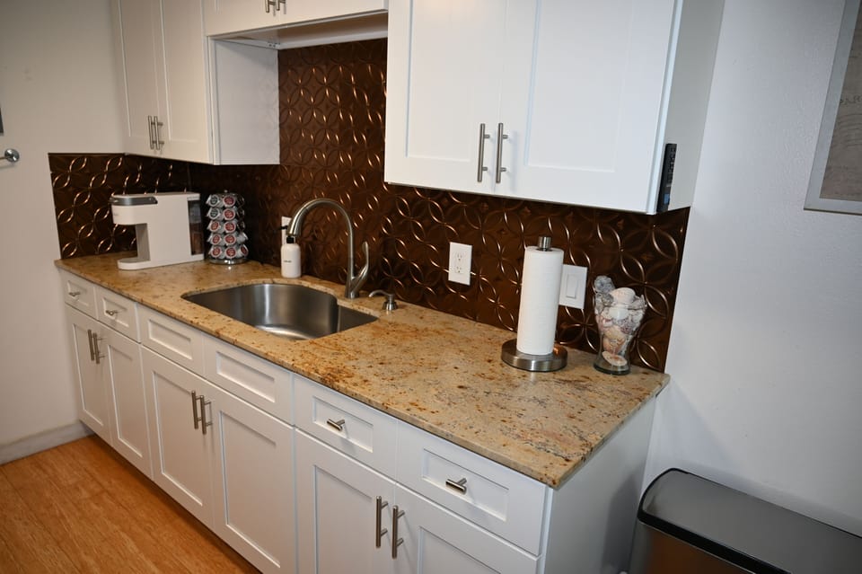 Stylish kitchenette with granite counters, coffee station, and modern finishes