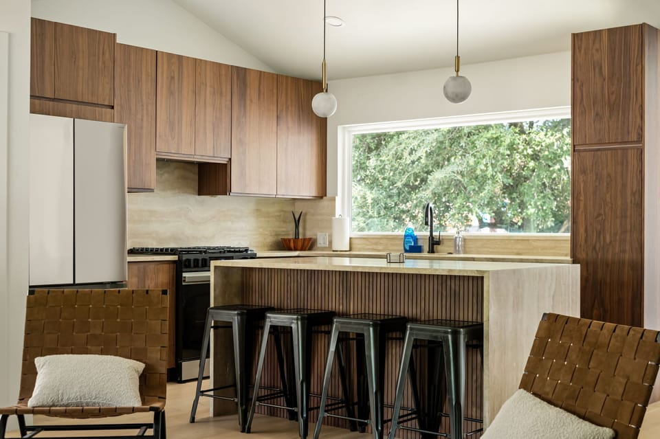Bright modern kitchen with island seating for 4 and oversized window
