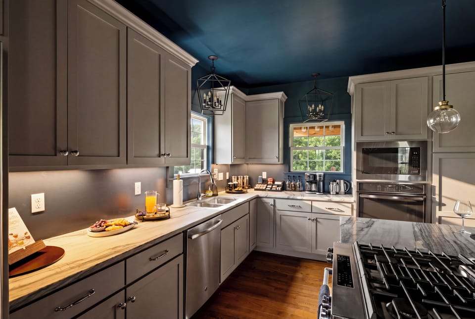 Chef’s kitchen with gas range, sleek finishes, natural light, and seating for four at the island