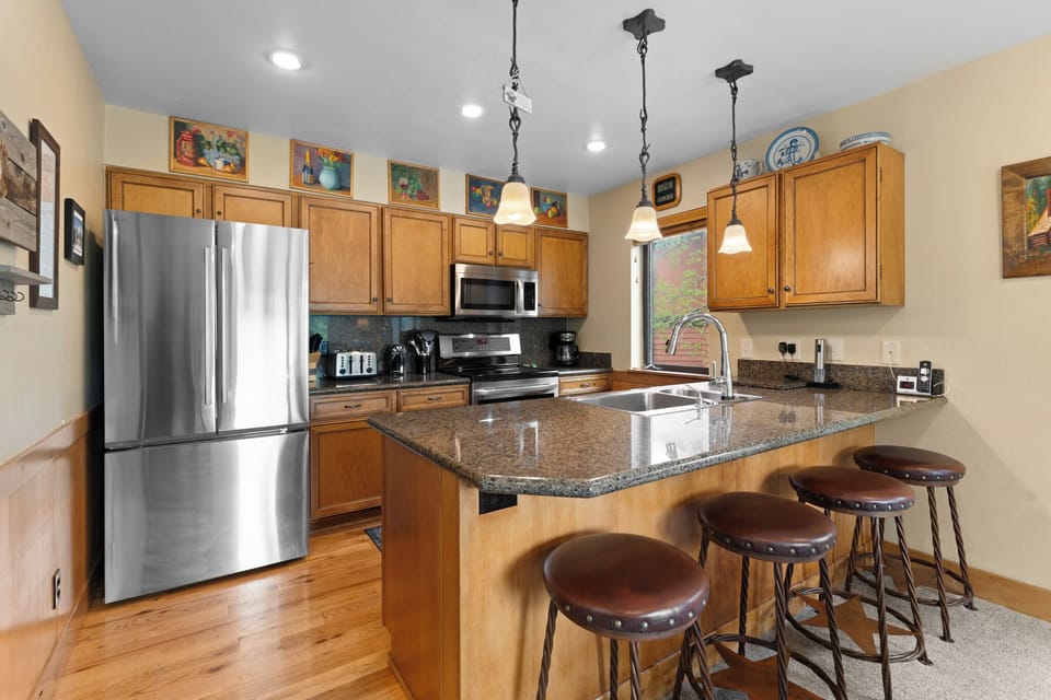 Your fully equipped kitchen invites morning coffee at the granite breakfast bar, with stainless appliances and everything you need to prepare meals together.