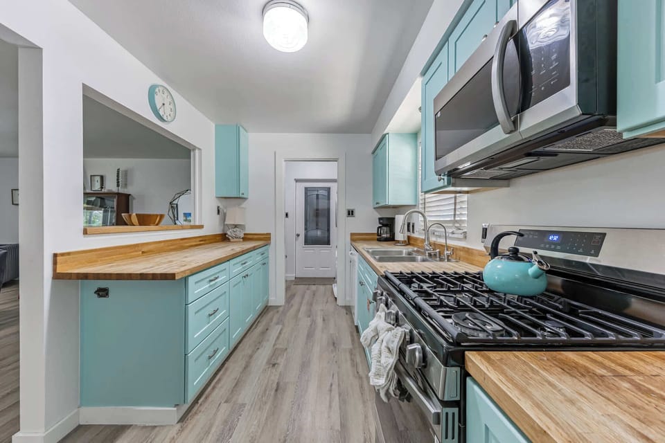 Bright kitchen with turquoise cabinets and wooden countertops for a fresh cooking experience