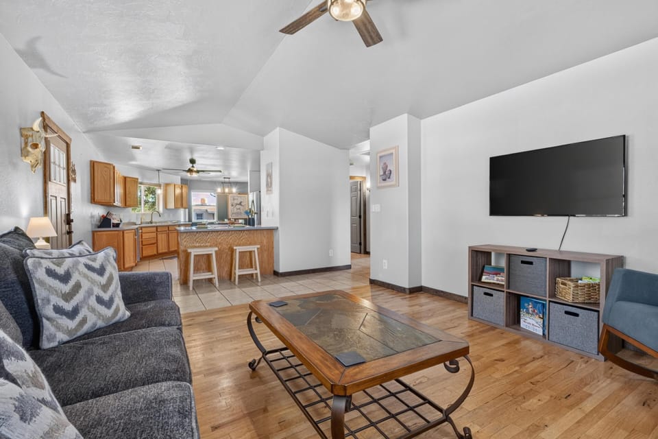 Slate-tiled coffee table sits on hardwood floors opposite a dark gray sofa in the open living area.