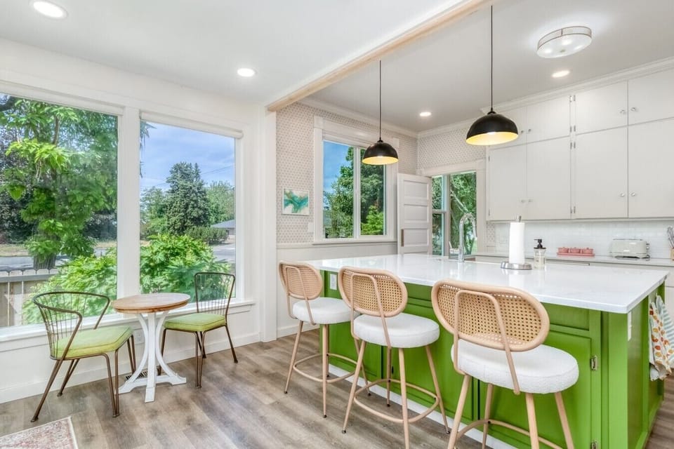 Sunny kitchen with island seating and space for morning coffee or casual meals.
