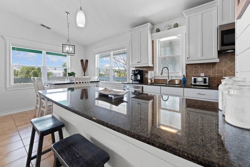 Bright and airy kitchen with granite countertops, island seating, and everything needed to prepare meals after a day in the Keys.