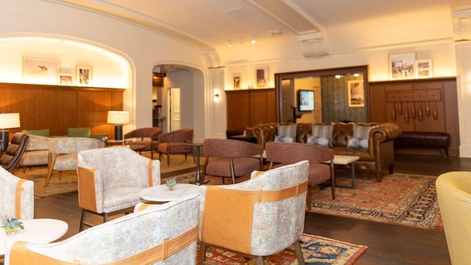 Meet, relax, and linger in layered seating around rich woodwork.