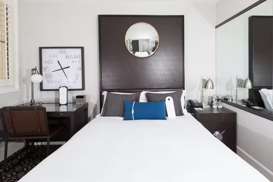Unwind in crisp linens beneath a bold, modern headboard.