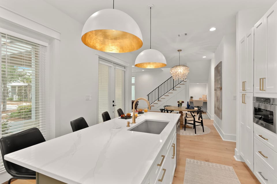 Beautifully framed view from the dining table transitioning into the high-end, modern chef's kitchen.