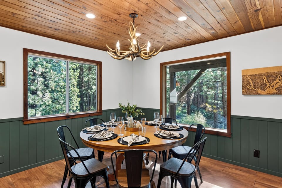 Forest-view dining area with warm wood ceilings and cabin-inspired style.
