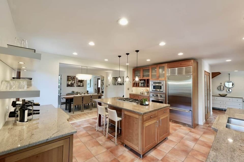 The living area flows naturally into a tasteful dining space and a
standout, fully equipped chef’s kitchen. Complete with a massive island, high-end
commercial appliances and a beautiful flow from the dining area to kitchen to outdoor patio!