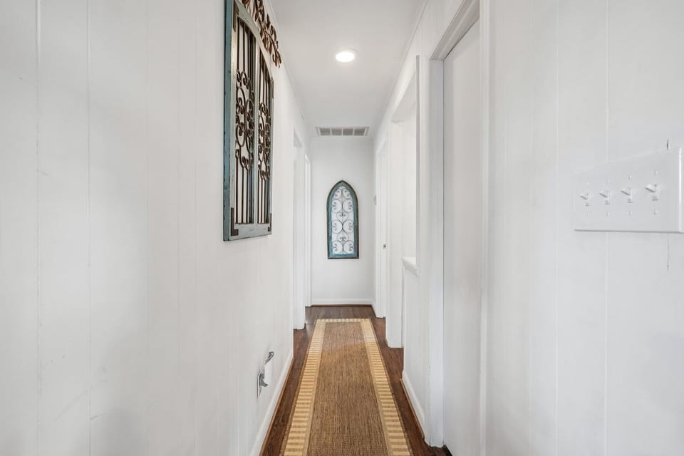 A bright hallway leads you to your private spaces, with warm wood floors, charming architectural details, and thoughtful touches like coat hooks welcoming you home.